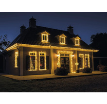 Huis met kerstverlichting op gevel, ramen en dak