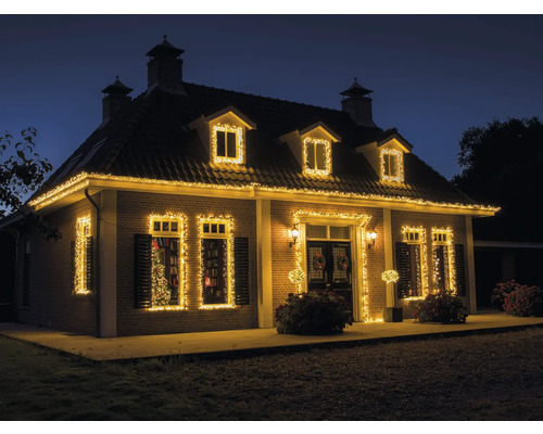 Huis met kerstverlichting op gevel, ramen en dak