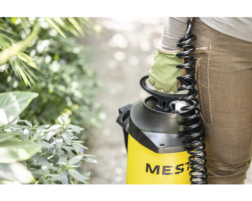 Persoon met drukspuit van Mesto in de tuin