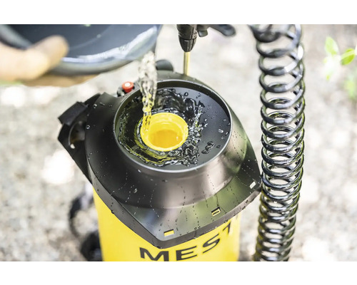 Vullen van een gele tuinspuit van het merk Mesto met vloeistof