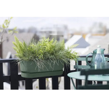Bloembak op een balkon met tafel en stoel