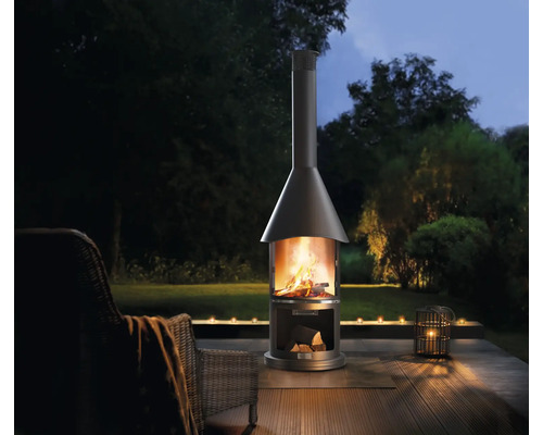 Buitenscène met tuinhaard, stoel en kaarsen voor een gezellige sfeer.