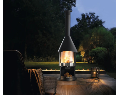 Tuinscene met tuinhaard, houtblokken en kaarsen