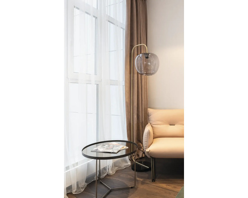 Woonkamer met vloerlamp, tafel en fauteuil