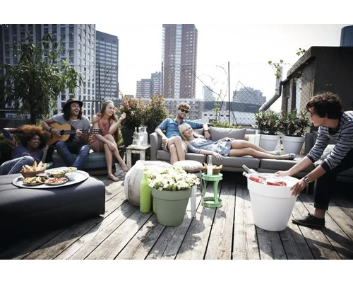 Groep mensen ontspant op een dakterras met meubels en plantenbakken.