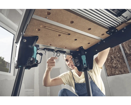 Een vrouw monteert een werkbank met haakophanging.