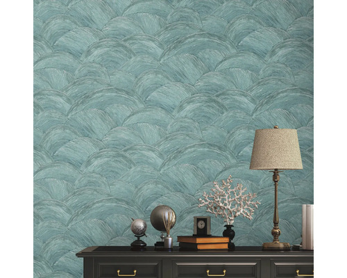 Decoratief behang met halfcirkelpatroon boven een dressoir met decoraties en een lamp