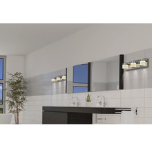 Lichte badkamer met wastafel, grote spiegel en wandlamp