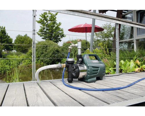 Metabo tuinpomp met slang op houten platform