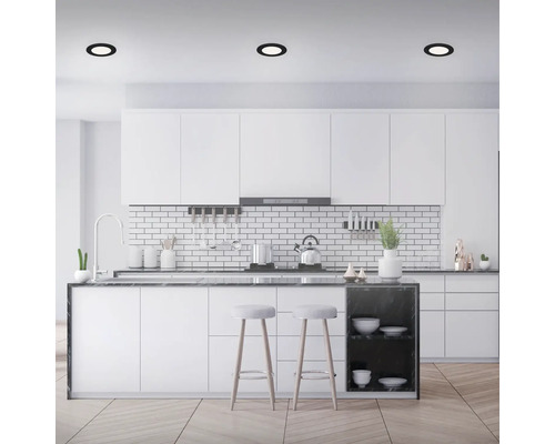 Lichte keuken met kookeiland, witte kasten en plafondlampen