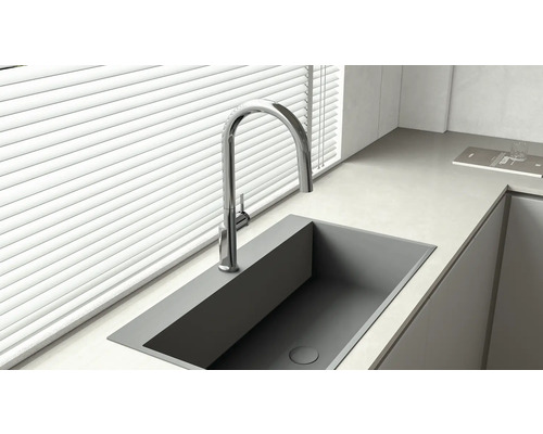 Roestvrijstalen aanrechtspoelbak met kraan onder een raam