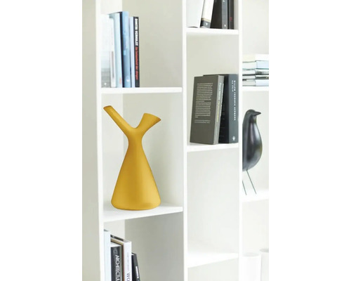 Witte boekenkast met gele gieter en boeken