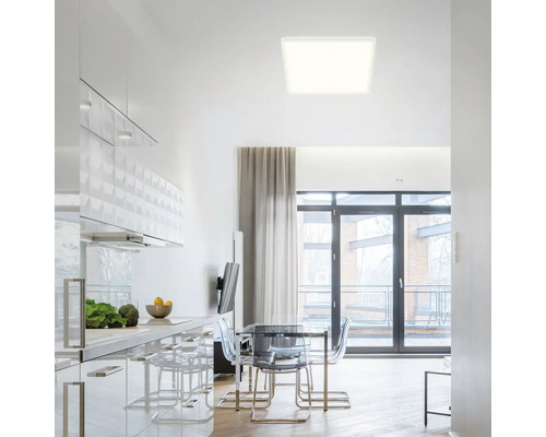 Moderne keuken met eettafel en vierkante plafondlamp.