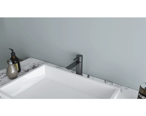 Moderne badkamer met witte wastafel en zwarte kraan op een marmeren blad