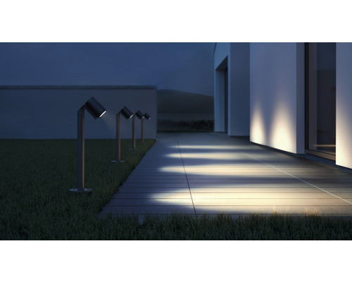 Verlichte oprit met meerdere tuinpadverlichting naast een huis