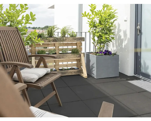 Balkon met houten stoelen, palletrek en plantenbakken op vloertegels