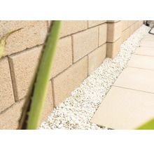Muur van betonnen stenen met decoratieve kiezelstenen en stoeptegels