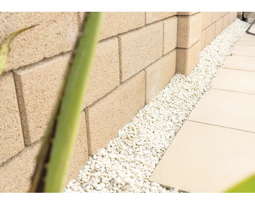 Muur van betonnen stenen met decoratieve kiezelstenen en stoeptegels
