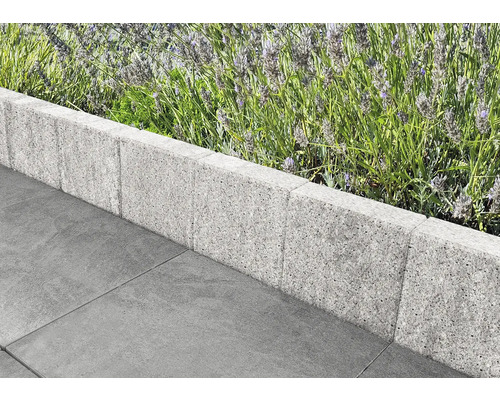 Betonnen borduursteenrand met bloembed