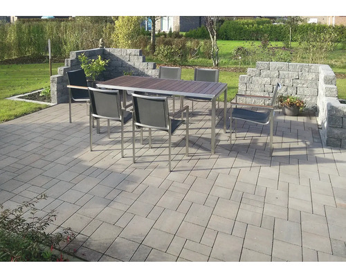 Tuinscène met eettafel, stoelen en stenen bestrating