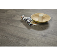 Gelegde vinylvloer met houtlook, een tijdschrift, een kaars en een schaal.