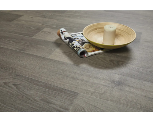 Gelegde vinylvloer met houtlook, een tijdschrift, een kaars en een schaal.