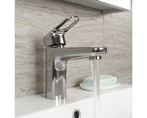 Glanzende wastafelmengkraan van metaal op een wastafel met stromend water