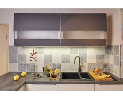 Moderne keuken met spoelbak, kraan, werkblad en hangkasten.