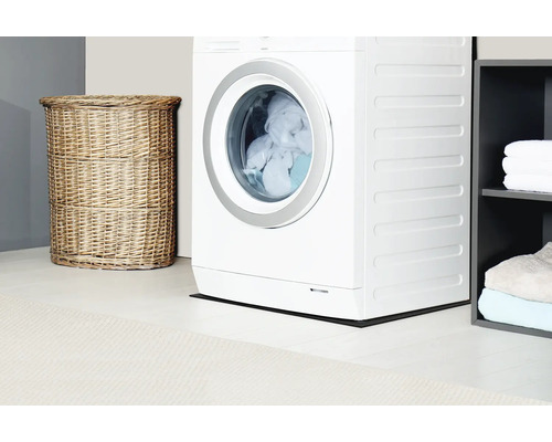 Wasmachine, wasmand van vlechtwerk en plank in de wasruimte