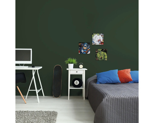 Gedecoreerde kamer met superheldenmotieven aan de muur boven het bed.