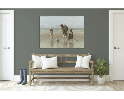 Schilderij van een gezin op het strand boven een houten bank in de hal.