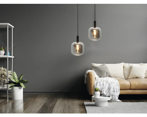 Woonkamer met twee hanglampen, bank en rek