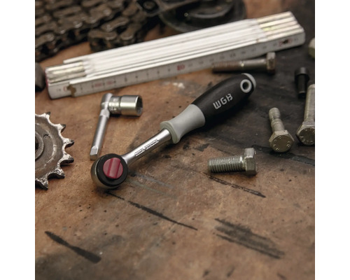 Ratelsleutel met dopsleutel en schroeven op werkbank