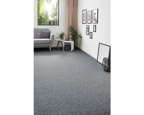 Woonkamer met grijze vloerbedekking, bank, ramen en decoratie