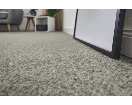 Close-up van een grijs tapijt in een woonkamer.