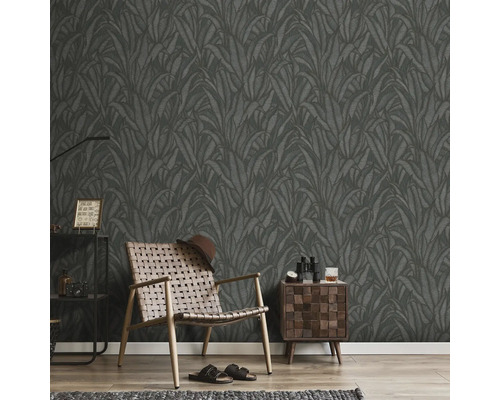 Kamer met donker bladbehang, fauteuil, nachtkastje en decoratie