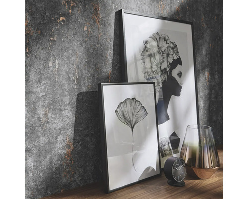 Decoratieve scène met twee ingelijste foto''s, een klok en een vaas op een plank voor een gestructureerde muur.