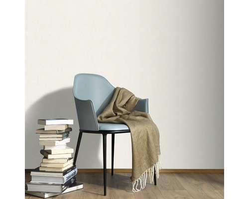 Lichte kamer met stapel boeken, stoel en deken