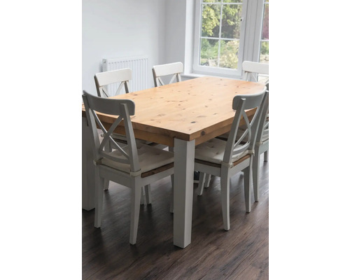 Eettafel met houten blad en witte stoelen in een lichte kamer