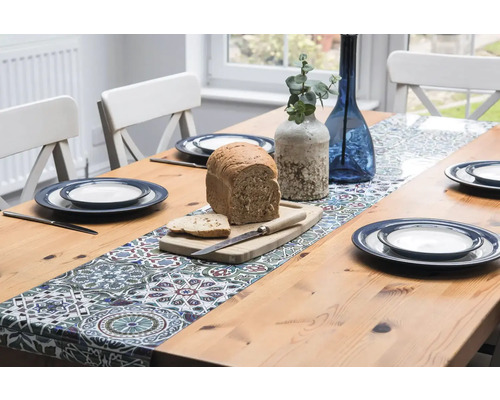 Gedekte eettafel met tafelloper, servies, vazen en brood