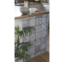 Keukeneiland met folie in tegelpatroon, servies en kamerplant voor een decoratieve keukeninrichting
