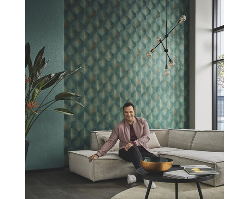 Woonkamer met geometrisch behang, hoekbank, kamerplant en decoratieve verlichting voor een stijlvolle ambiance