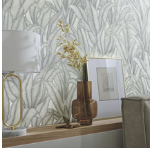 Decoratief behang met bladmotief in een woonkamer met lamp en decoratie