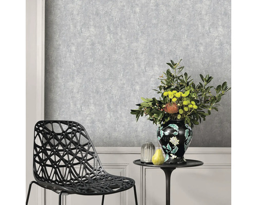 Scene met een grijs gestructureerd behang, een stoel en een tafel met een bloemenvaas