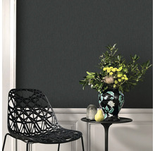 Scene met structuurbehang, een stoel, een tafel met bloemenvaas en decoraties.