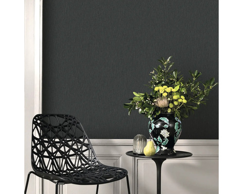 Scene met structuurbehang, een stoel, een tafel met bloemenvaas en decoraties.