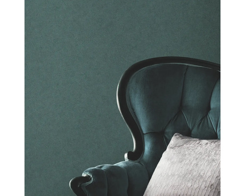 Close-up van een gestoffeerde fauteuil met kussen voor een muur