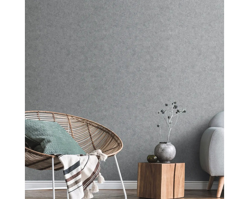 Grijze wanddecoratie met stoel, bijzettafel en bank in de woonkamer.