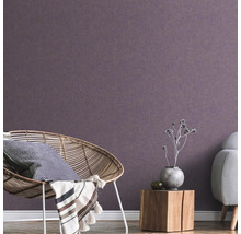 Woonkamer met rotan stoel, houten tafel en vliesbehang