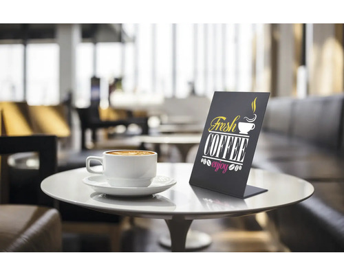 Tafeldisplay met het opschrift Fresh Coffee naast een kop koffie op een tafel